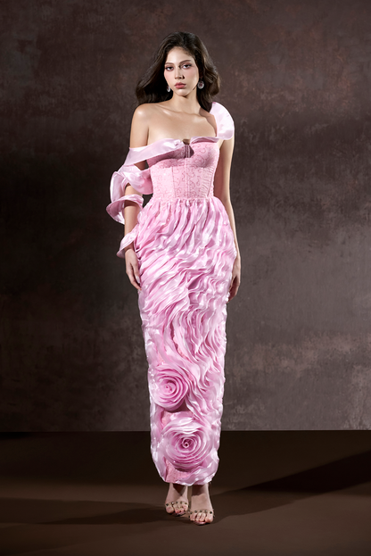 Woman wearing a pink floral dress against a dark background