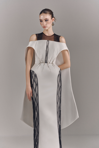 Model wearing a white off-shoulder dress with black mesh panels on a gray background