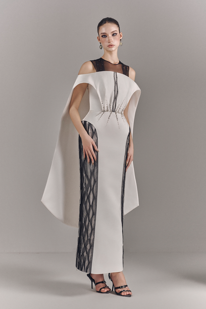 Woman wearing a stylish white dress with black accents on a gray background