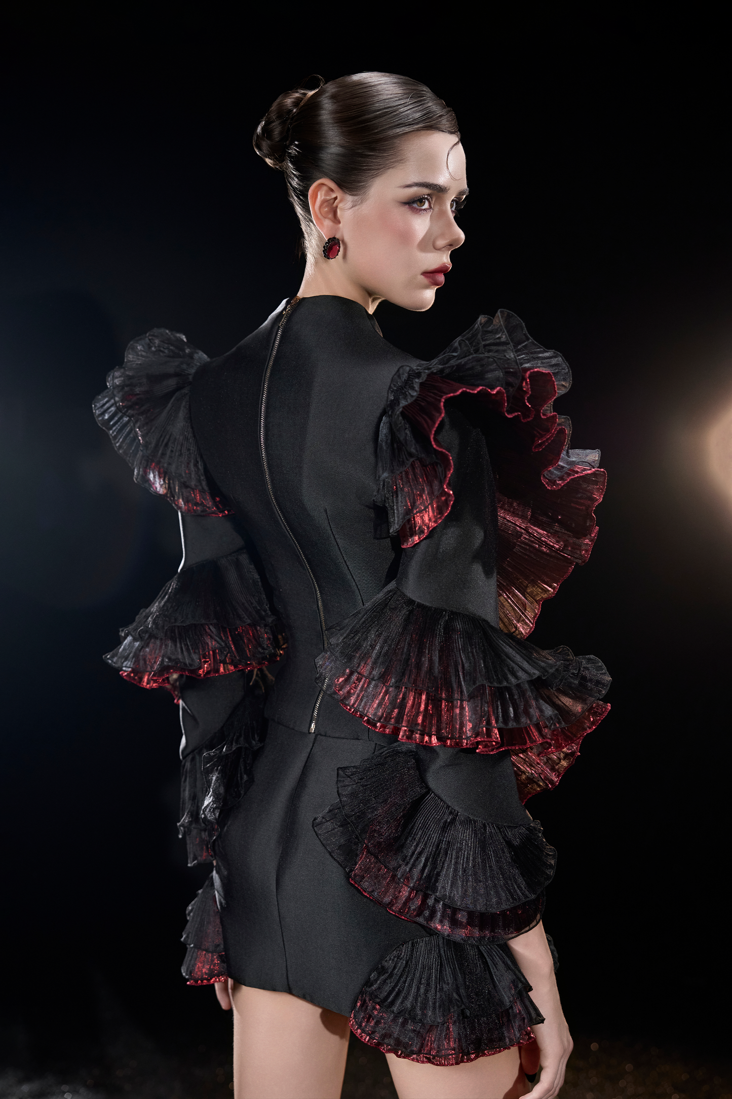 Woman wearing a black dress with red ruffles