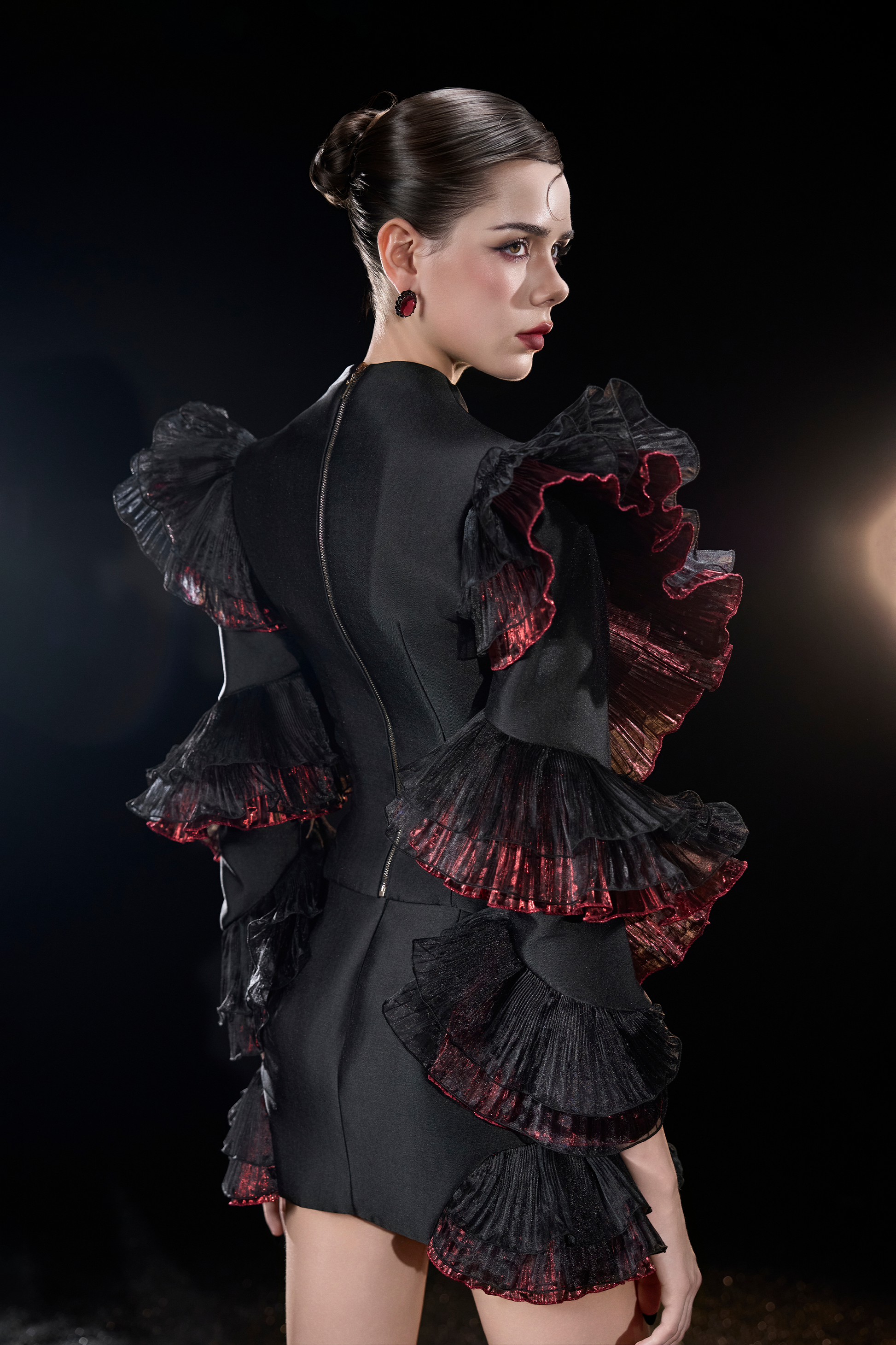 Woman wearing a black dress with red ruffles