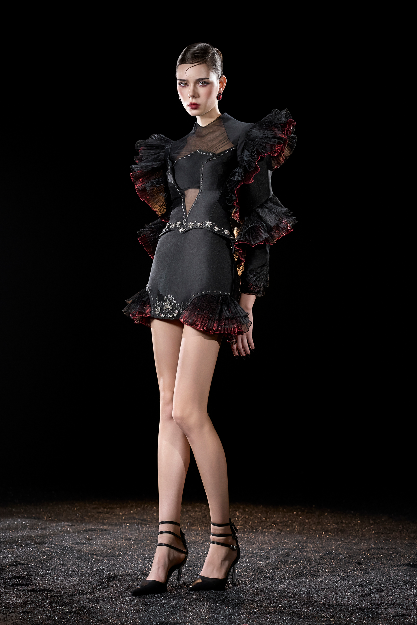 Model wearing a black and red outfit with ruffled sleeves