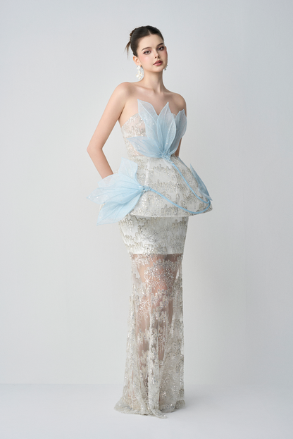 Model wearing a light blue and white floral dress with a plain background