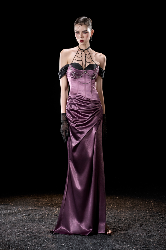 Woman wearing a long purple dress with black accents 