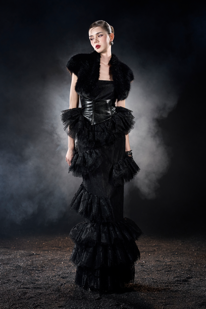 Woman in a black, layered dress with fur accents