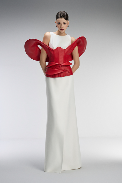 Woman wearing a red and white dress with a unique design on a gray background