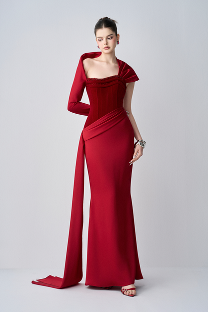 Red evening gown with a draped design on a white background
