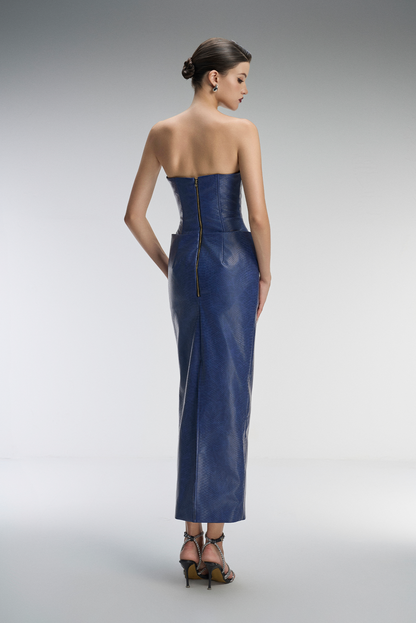Woman wearing a strapless blue evening gown on a gray background
