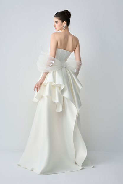 White strapless gown with ruffled details on a white background
