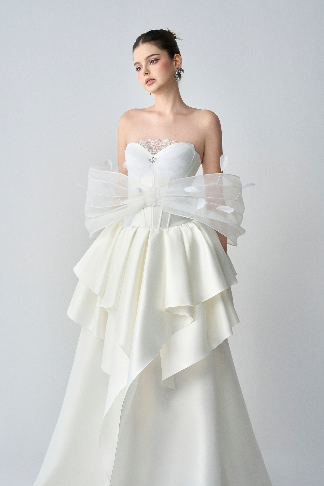 White strapless wedding dress with ruffled sleeves on a plain background