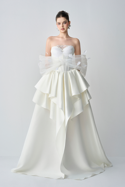 White strapless gown with ruffled layers on a white background