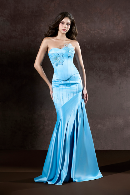 Woman wearing a blue evening gown against a dark background