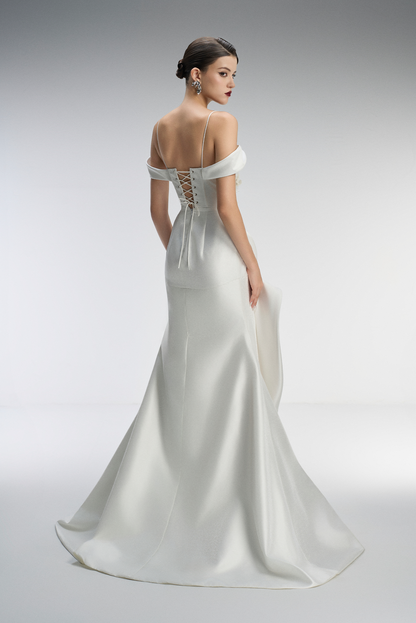 White wedding dress with lace back on a model against a gray background