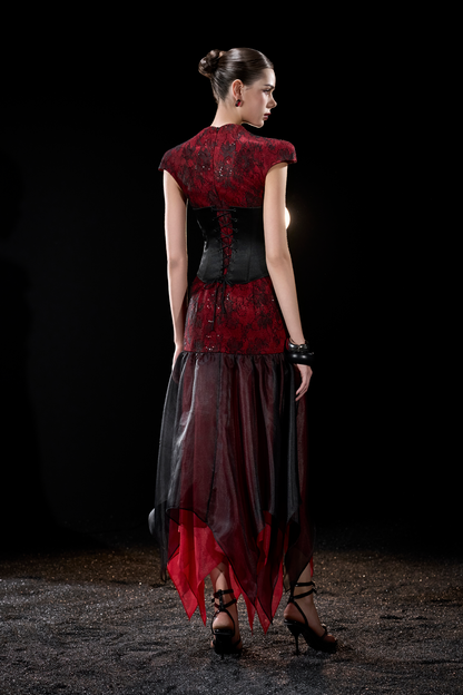 Model wearing a red and black dress with sheer overlay 