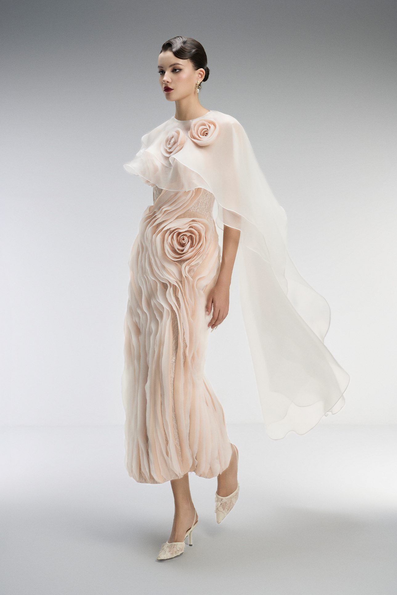 Woman wearing a elegant dress with floral details on a plain background