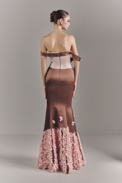 Woman wearing a strapless gown with floral details on a gray background