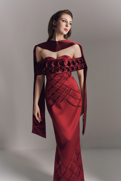 Red evening gown with intricate design on a gray background