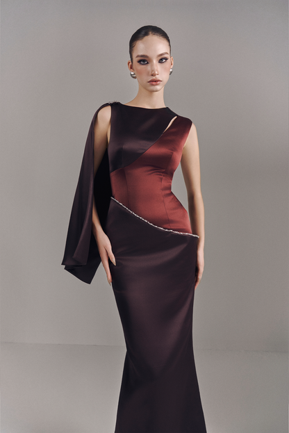Woman wearing a black and red evening gown against a neutral background