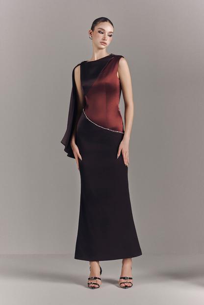 Woman wearing a black and red dress against a gray background