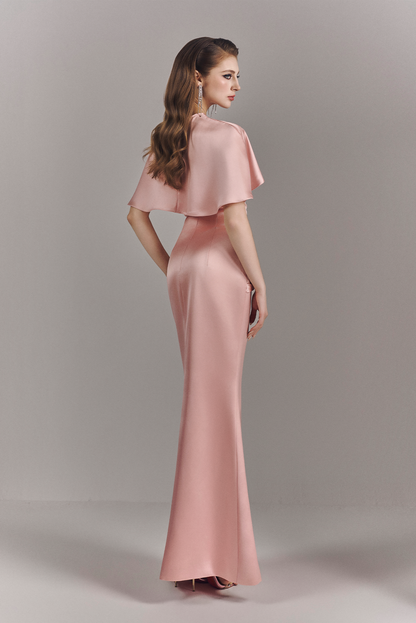 Woman wearing a pink evening gown against a plain background