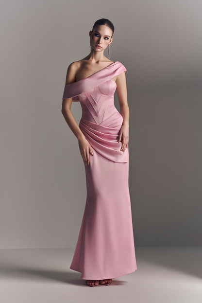 Woman wearing a pink one-shoulder evening gown against a plain background