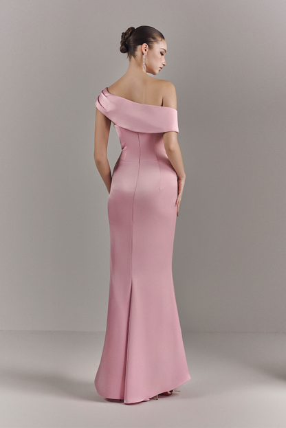 Woman wearing a pink off-shoulder gown against a plain background