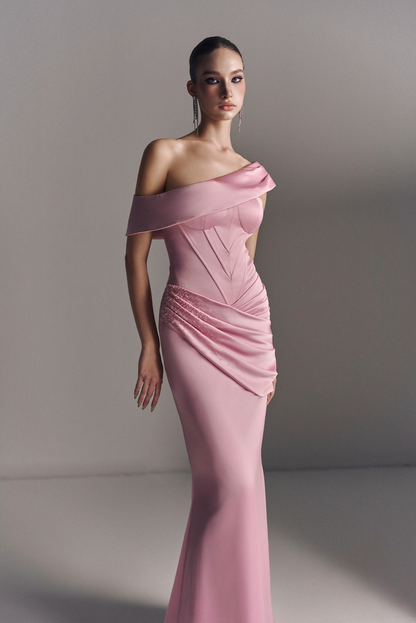Woman wearing a pink off-shoulder evening gown against a plain background
