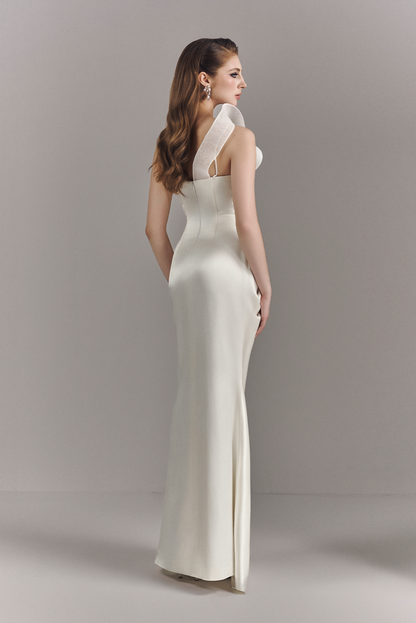 Woman wearing a white evening gown against a plain background