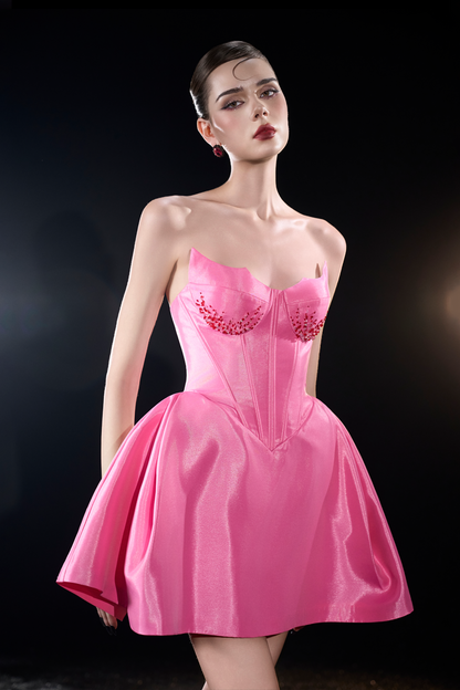 Model wearing a pink dress with floral embellishments