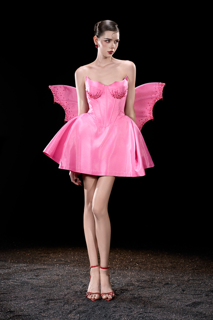 Model wearing a pink fairy costume with wings 