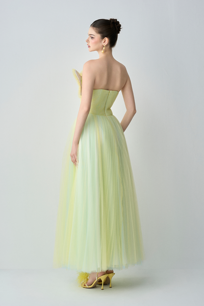 Woman wearing a light green strapless gown on a white background