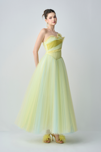 Woman wearing a strapless yellow evening gown on a white background