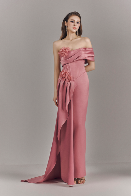 Woman wearing a pink strapless gown with floral details on a gray background