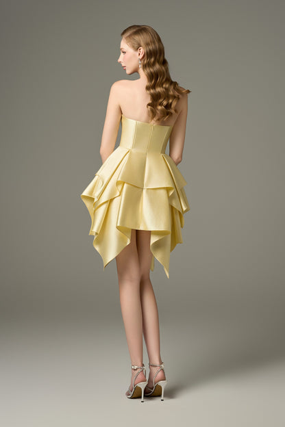 A back view of a Soleil yellow bodycon mini dress, showcasing its corset bodice and a multi-layered, asymmetrical hem that is shorter in the front.