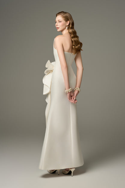 A full-length back view of a Devotion ivory acetate maxi dress, showcasing its figure-hugging fit and the flowing silhouette of the skirt.