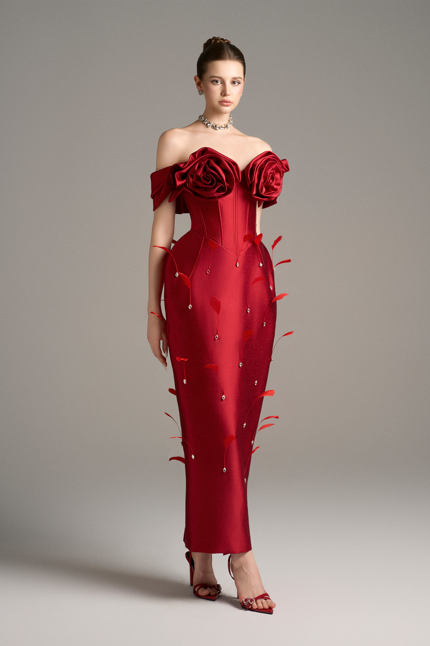  Elegant off-shoulder red maxi dress with handcrafted 3D roses, a corset bodice, and crystal bead and feather embellishments, showcasing a sophisticated design.