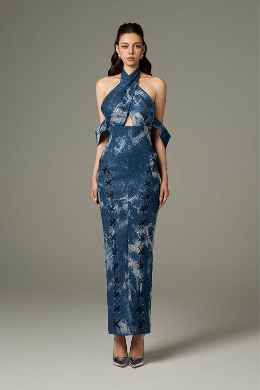 A full-length front view of a chic modest blue cotton denim halter tie-dye maxi dress, featuring a figure-hugging fit, halter neckline, off-shoulder sleeves, and front criss-cross black laces.