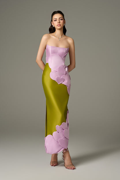 A close-up front view of a Darling color mix taffeta maxi dress, highlighting the bandeau neckline and the intricate, handcrafted heart-shape embellishments on the bodice and hip.