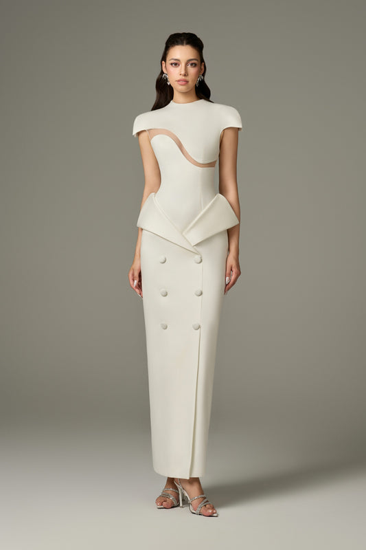 A full-length front view of a Vogue white short sleeve wave cut-out maxi dress, featuring a figure-hugging fit, round neckline, tailored shoulders with short sleeves, a wave cut-out detail on the bodice, and a peplum detail at the waist over a straight skirt with buttons and a front slit.