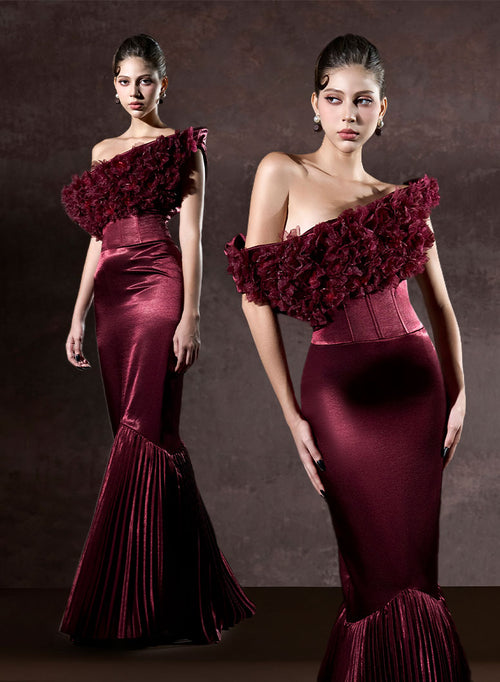 Wearing burgundy evening gowns with floral details against a dark background