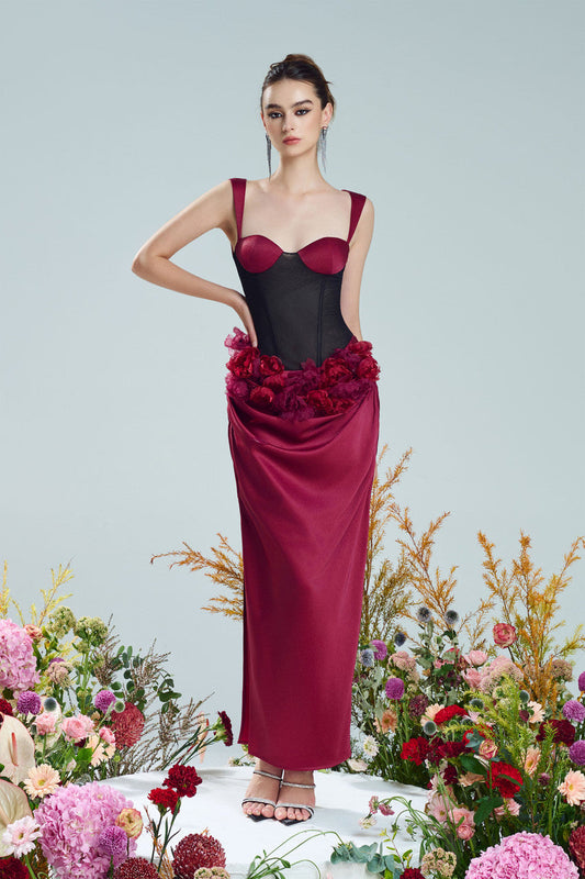 A red silk dress, detailed with black mesh corset bodice and floral accents.