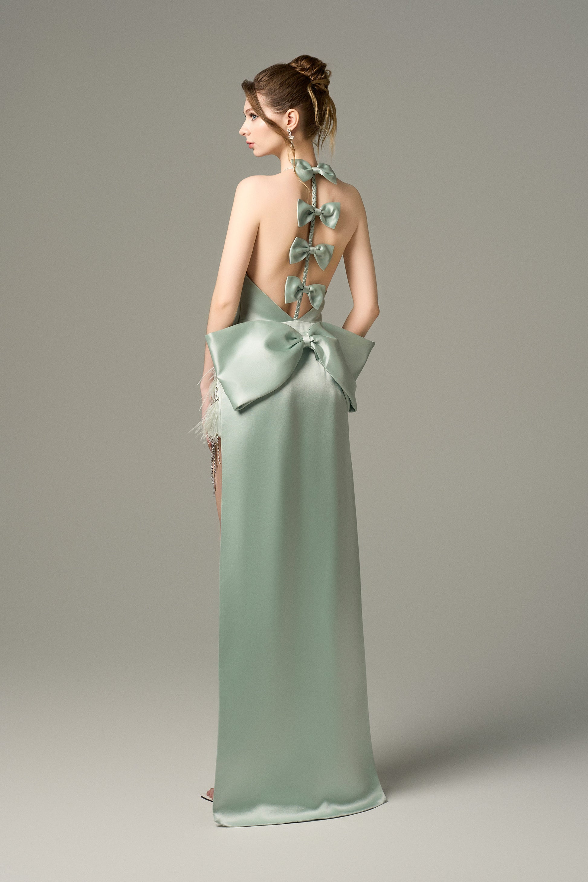 Turn heads in Light Green Silk Mini Dress, featuring a halter neckline, oversized bow, and crystal embellishments. 
