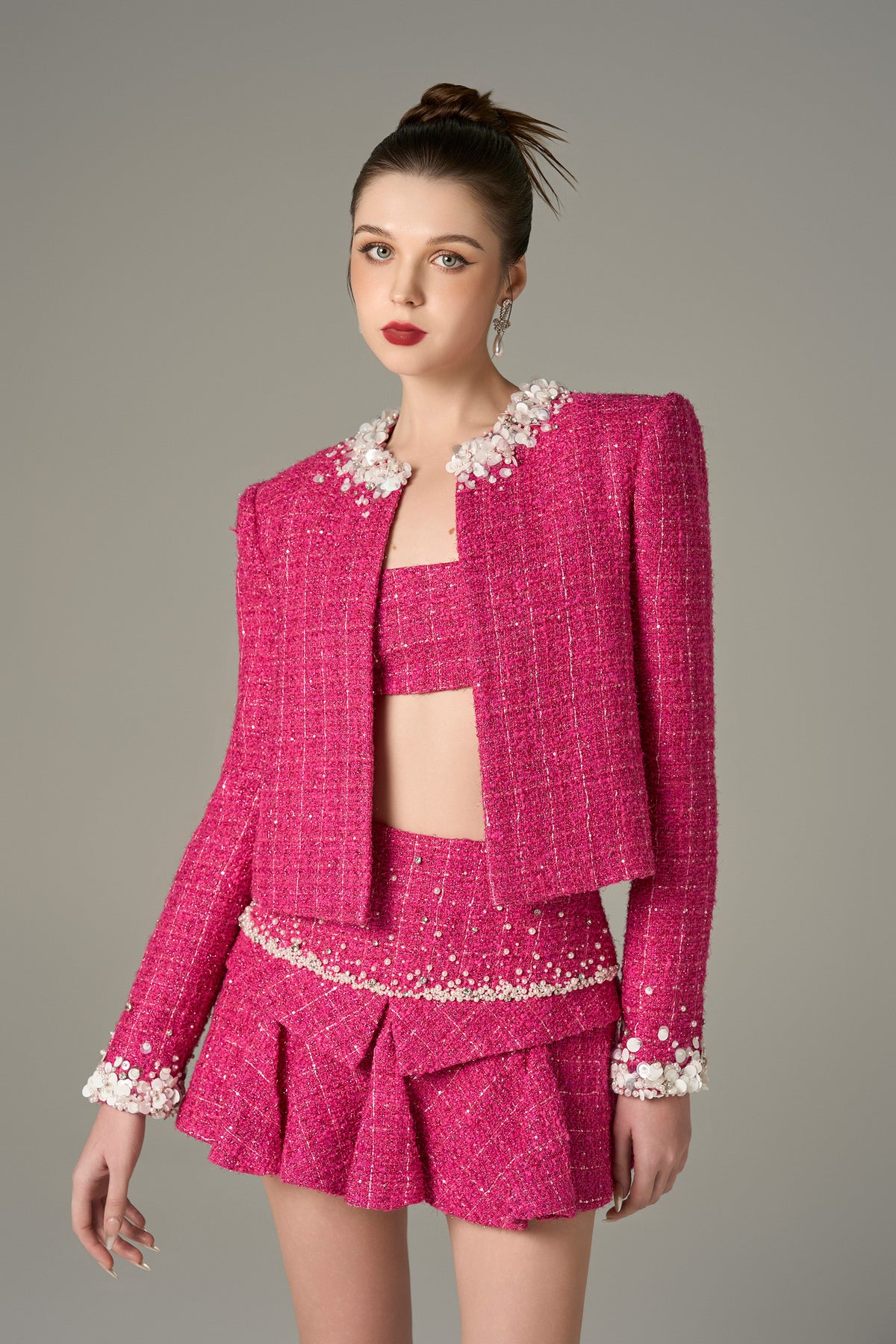 Pink tweed jacket with pearls on collar and sleeves.