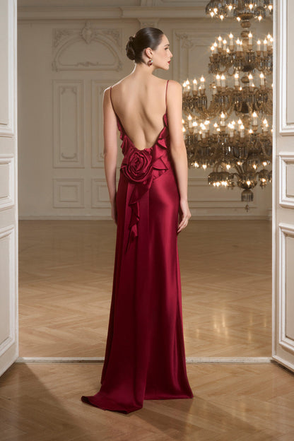 The red dress, adorned with soft pleats and ruffles, delicate spaghetti straps, intricate floral detailing and open-back design. 