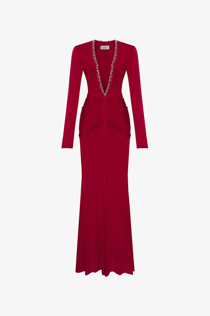 The red maxi dress in spandex, featuring a deep V-neckline with embellished crystals and ruching on both sides.