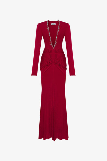 The red maxi dress in spandex, featuring a deep V-neckline with embellished crystals and ruching on both sides.