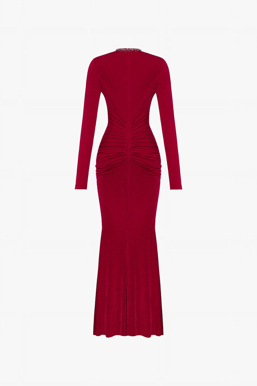 The red maxi dress in spandex, featuring a deep V-neckline with embellished crystals and ruching on both sides.