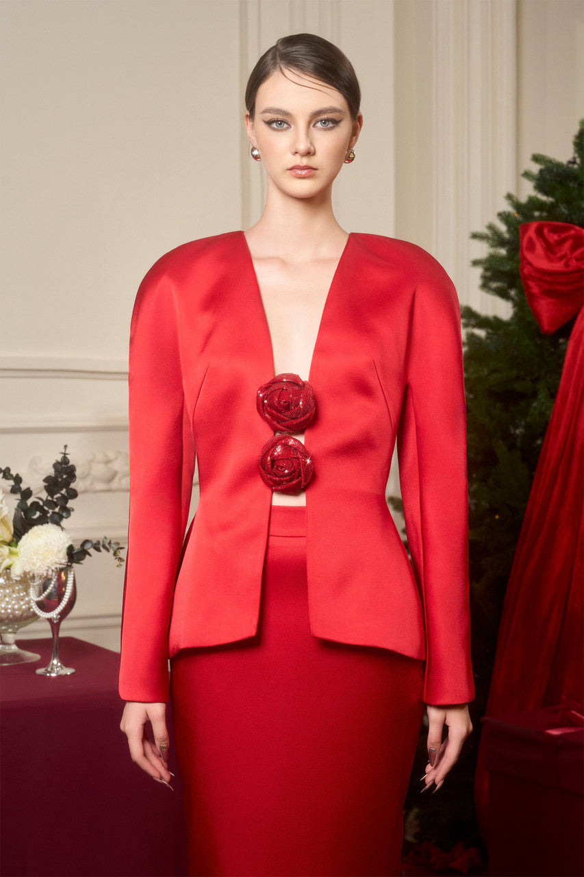 An red ensemble in taffeta, featuring a jacket with sequin floral embellishments and a high-waisted pencil skirt.