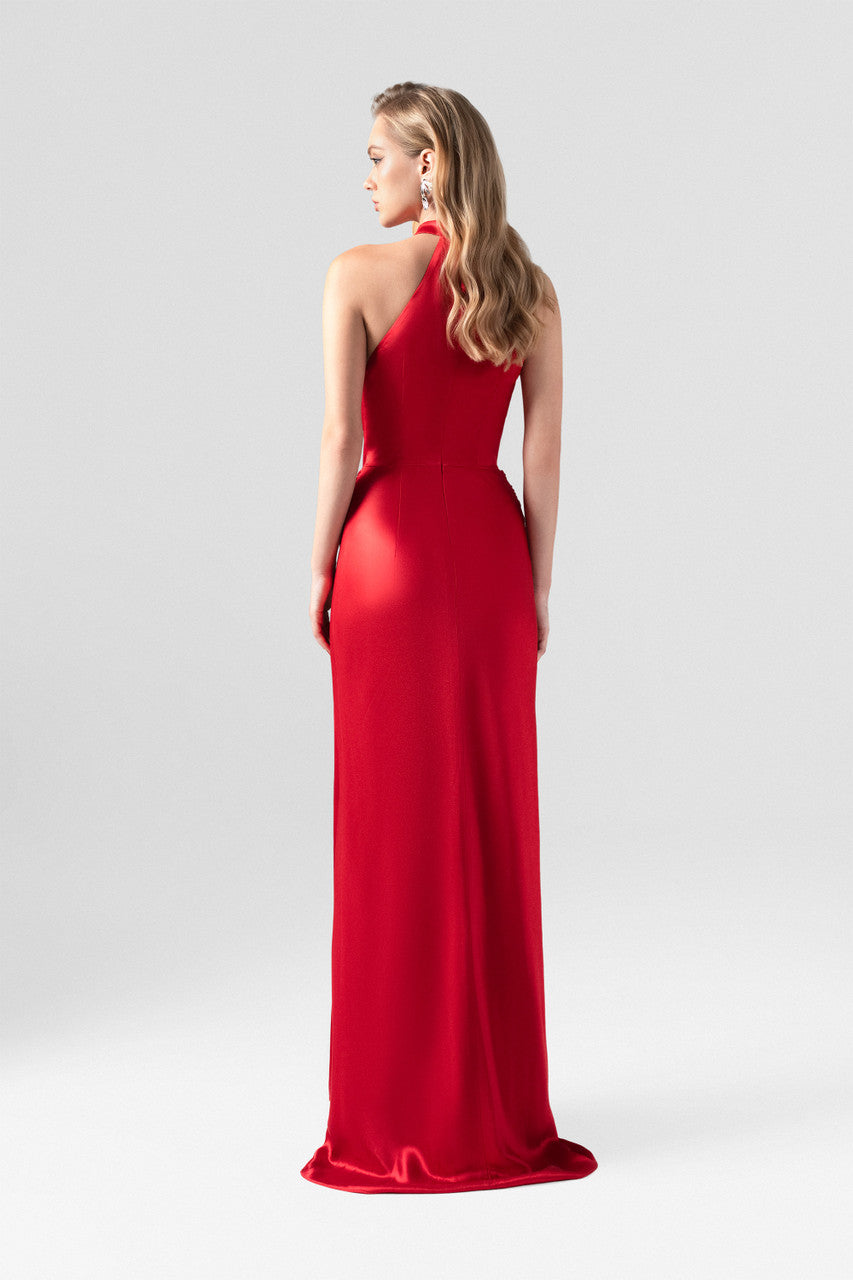 Red evening dress in silk with plunging neckline, sleeveless halter design.