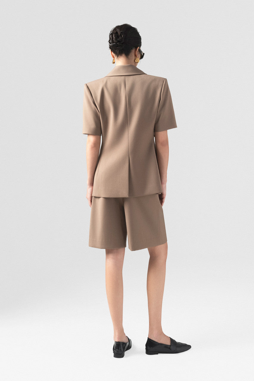 The short-sleeve brown blazer with wide padded shoulders and short menswear with chic waistband detail.